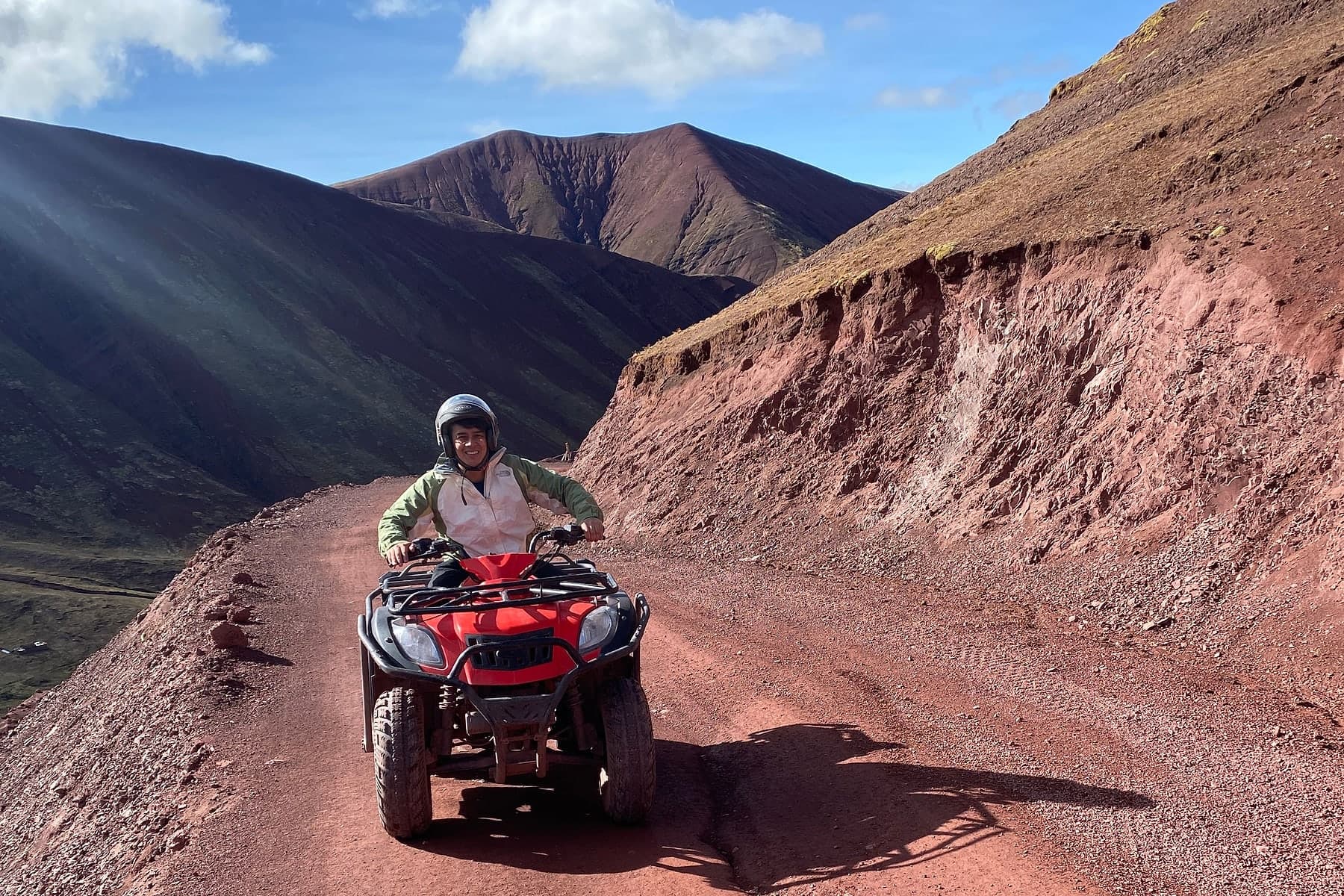 A rider on an ATV on the trail up towards the Rainbow Mountain viewpoint